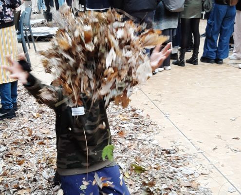 A child throwing dried leaves into the air